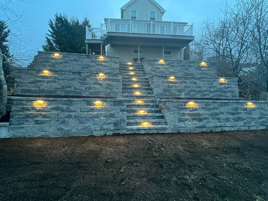 Terraced stone retaining walls with a central staircase and illuminated wall accents
